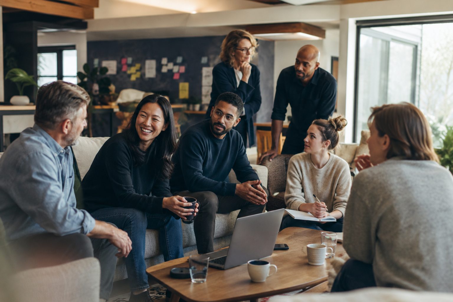 A small professional team in conversation during a corporate retreat, in a bright, designed offsite space