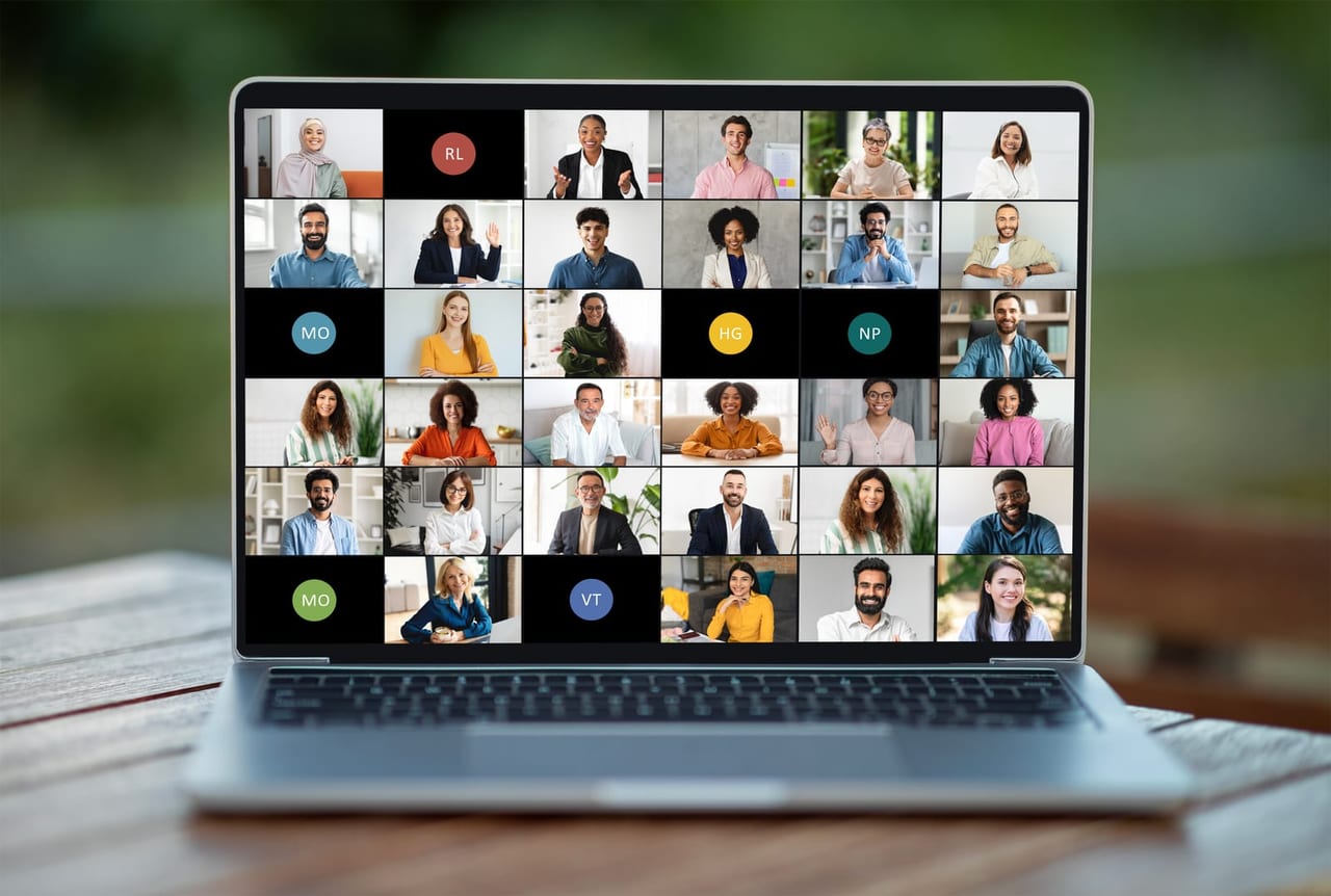 A distributed team on a video call, shown as a grid of participants on a laptop screen